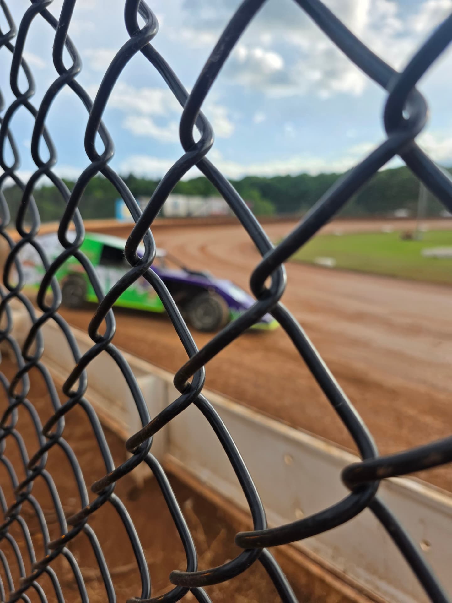 Ryan Johnston #11 EconoMod on track seen through the catch fence