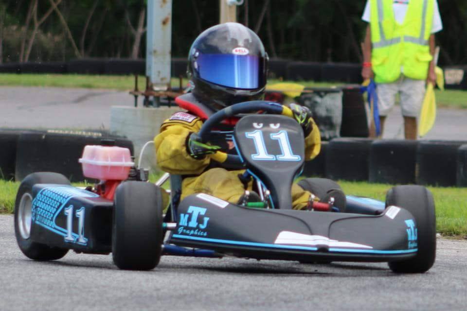Young Ryan Johnston driving #11 go-kart in yellow racing suit during early career
