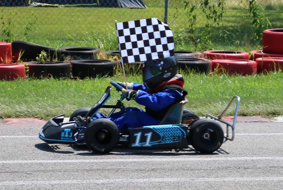 Young Ryan Johnston taking checkered flag in #11 go-kart during early racing career