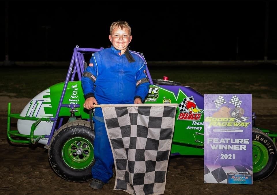 Ryan Johnston 2021 Feature Winner holding checkered flag with #11 car