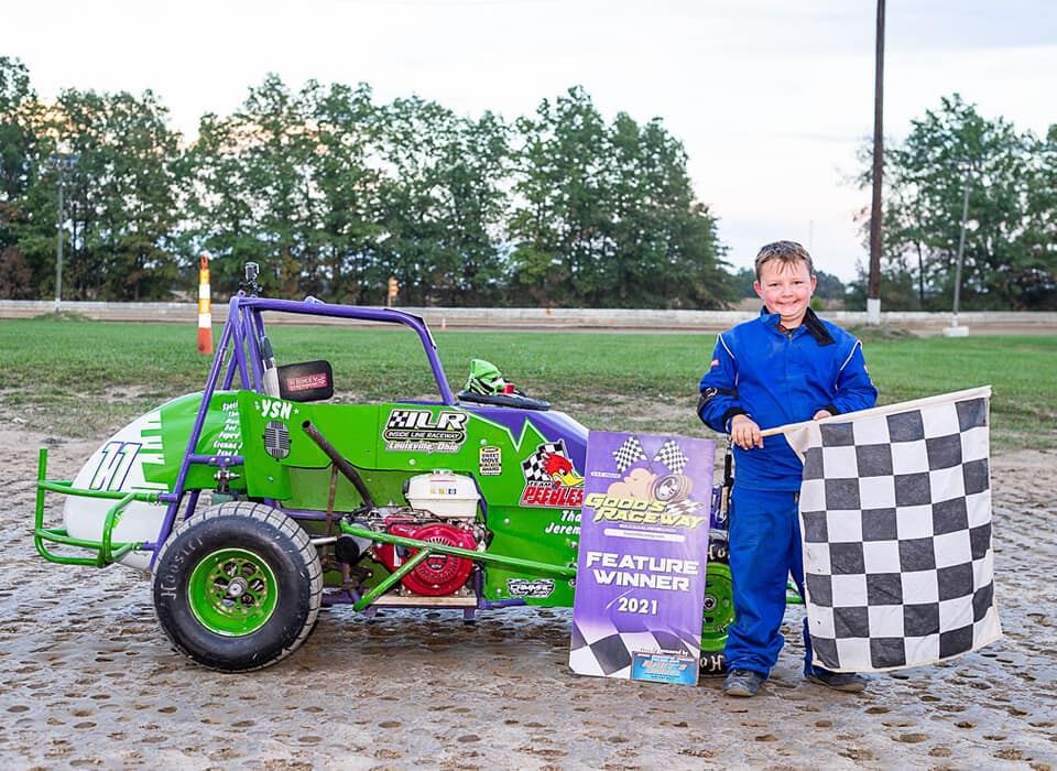 Ryan Johnston 2021 Feature Winner posing with checkered flag and #11 car