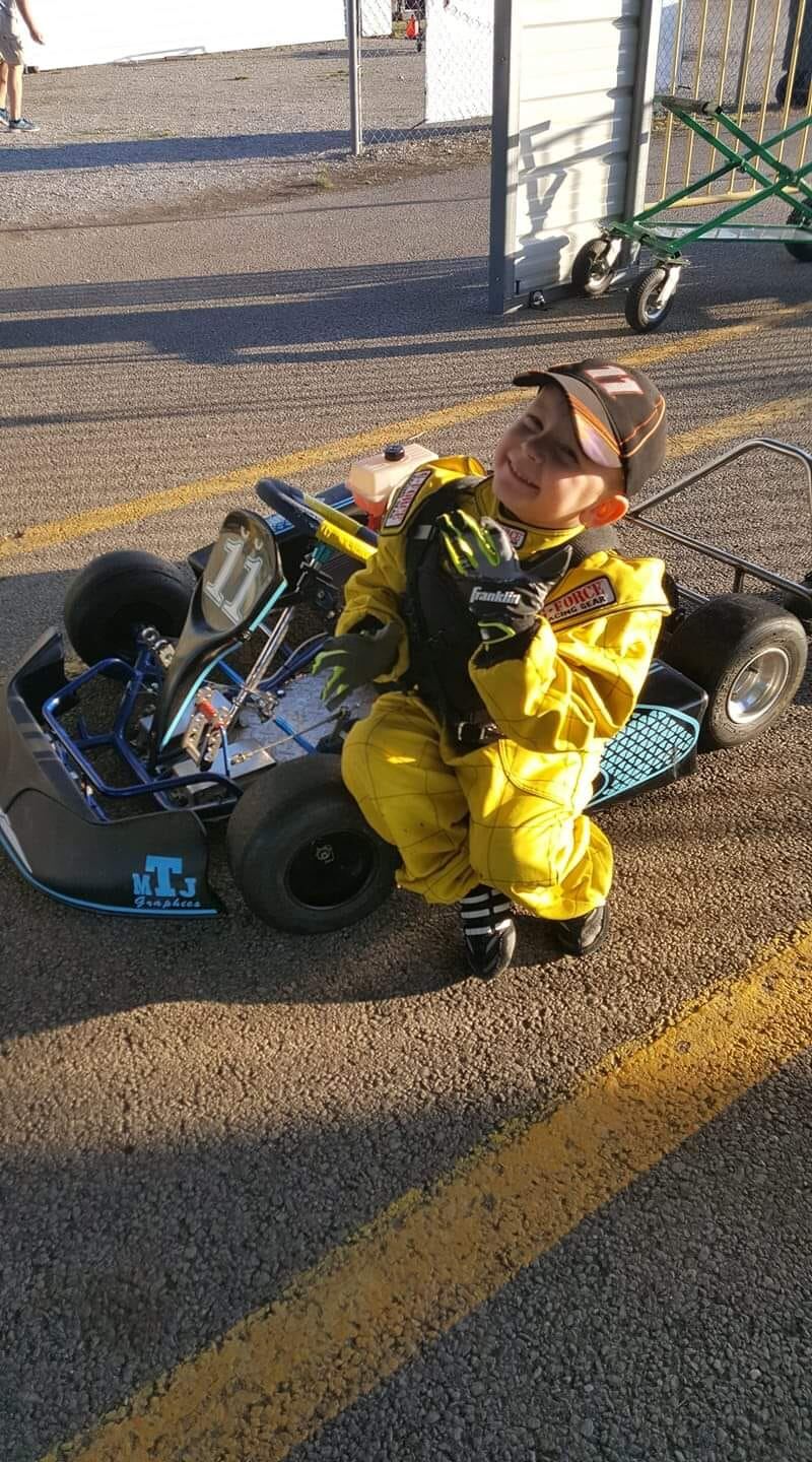 Young Ryan Johnston in yellow racing suit with go-kart early racing career